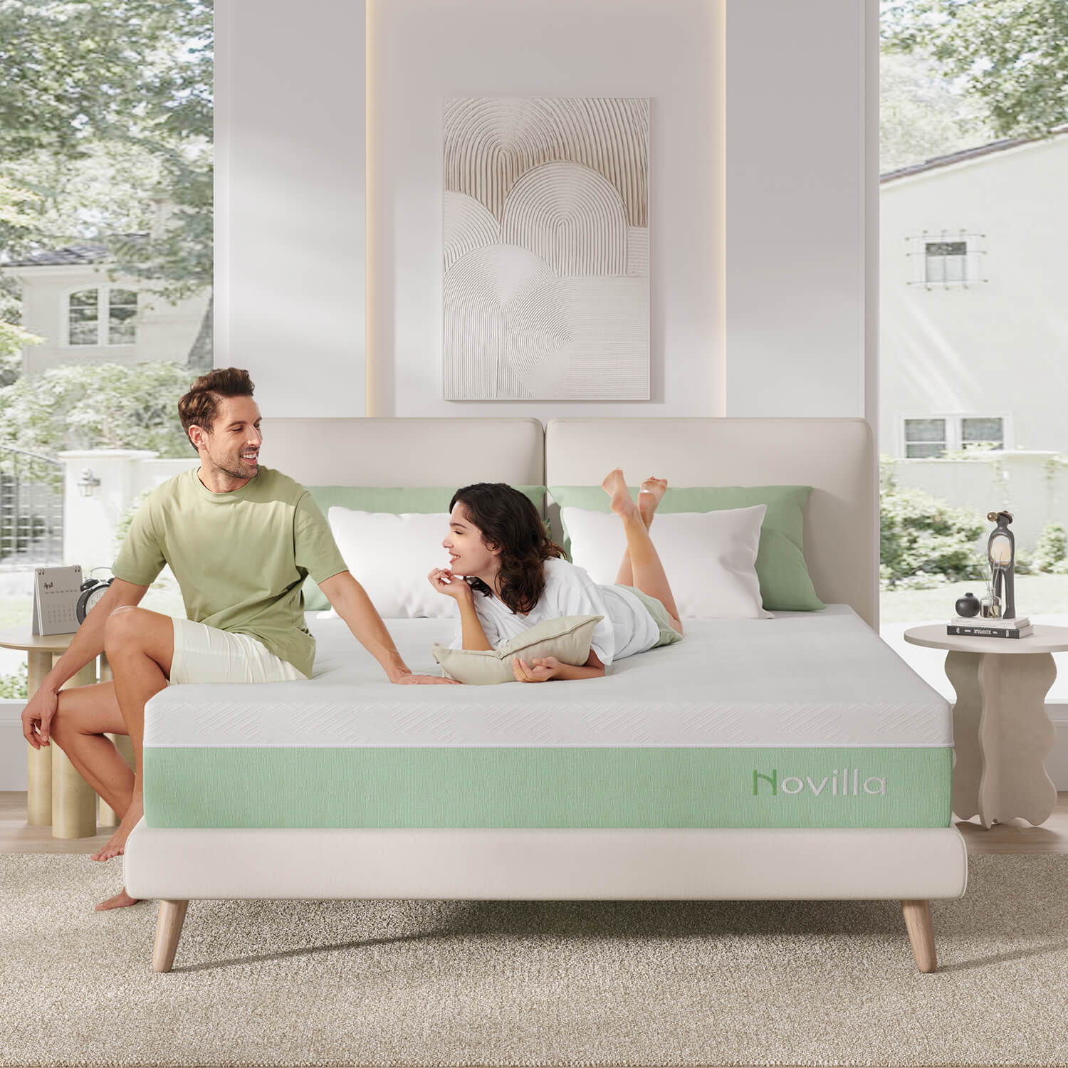 Couple relaxing on Verdant Novilla memory foam mattress, white textured top, green side band, light bedroom.