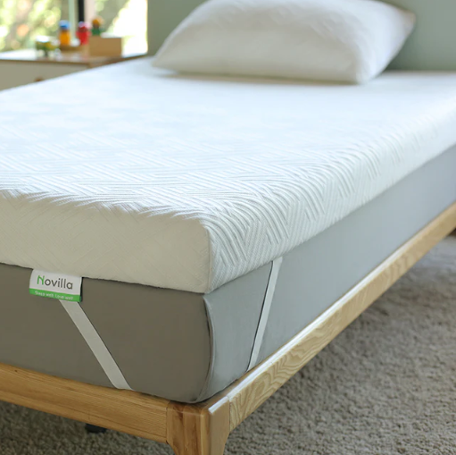 Novilla white memory foam mattress topper with elastic corner straps on a grey mattress