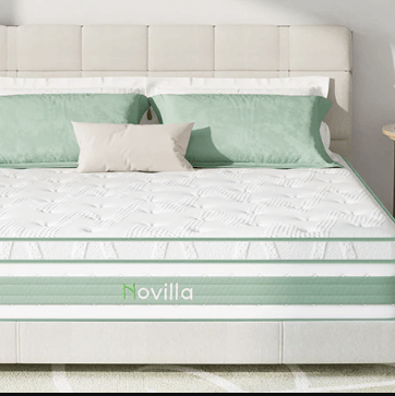 A close-up of a Novilla mattress on a bed with a white tufted headboard, styled with green and white pillows