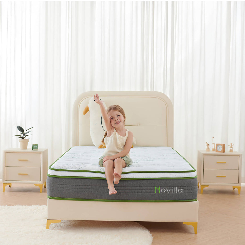 A young girl sits smiling on a Novilla mattress in a bright, modern bedroom