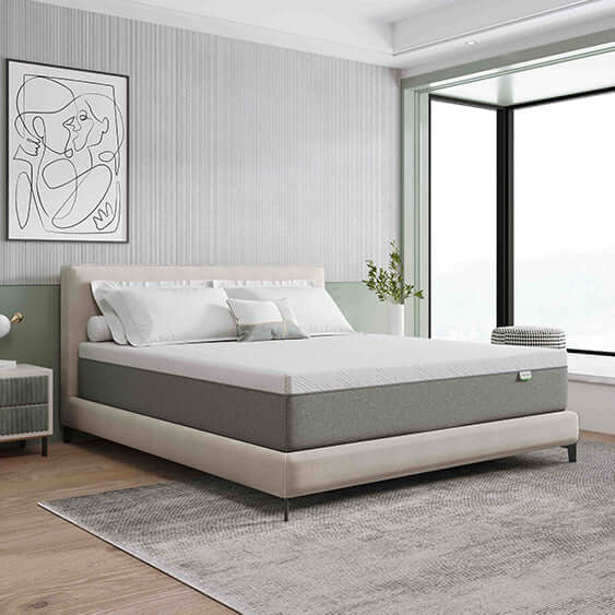 A modern bedroom with a bed featuring a white and grey mattress, a large window, and a framed art piece on the wall
