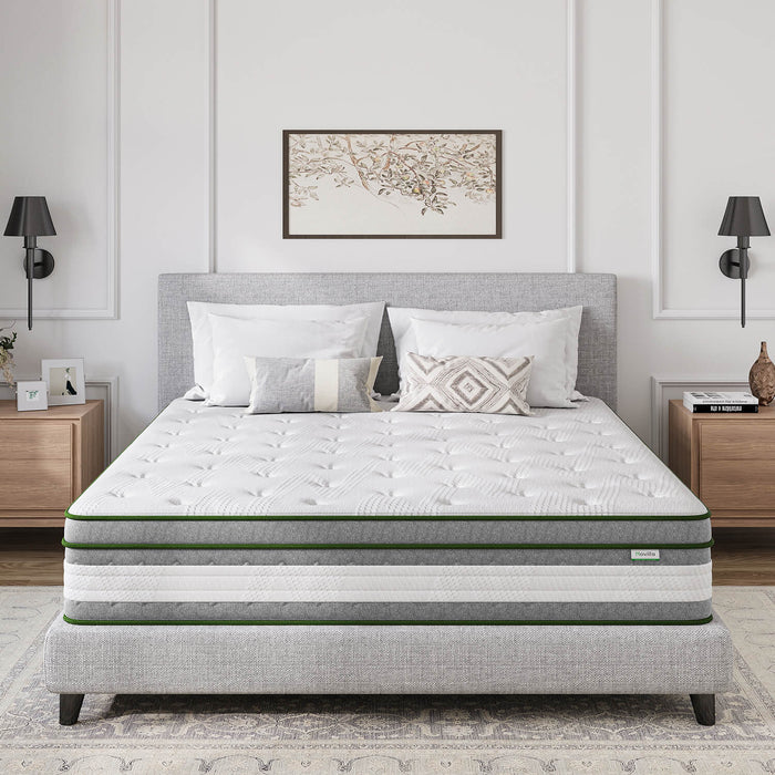 12-inch Vitality Hybrid Mattress with green trim, pillows, and bedding on a grey upholstered bed frame.
