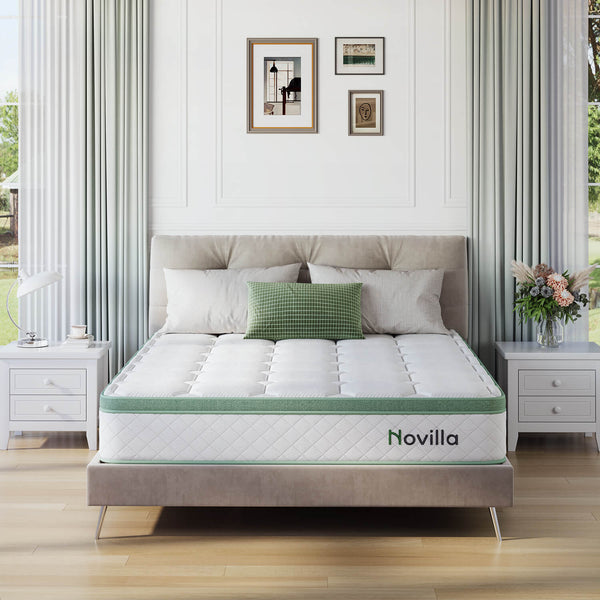 Novilla white memory foam pocket sprung mattress with green trim on a bed in a bedroom.