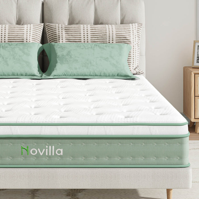 Oasis hybrid mattress white top green side panel Novilla logo light green pillows gray headboard.