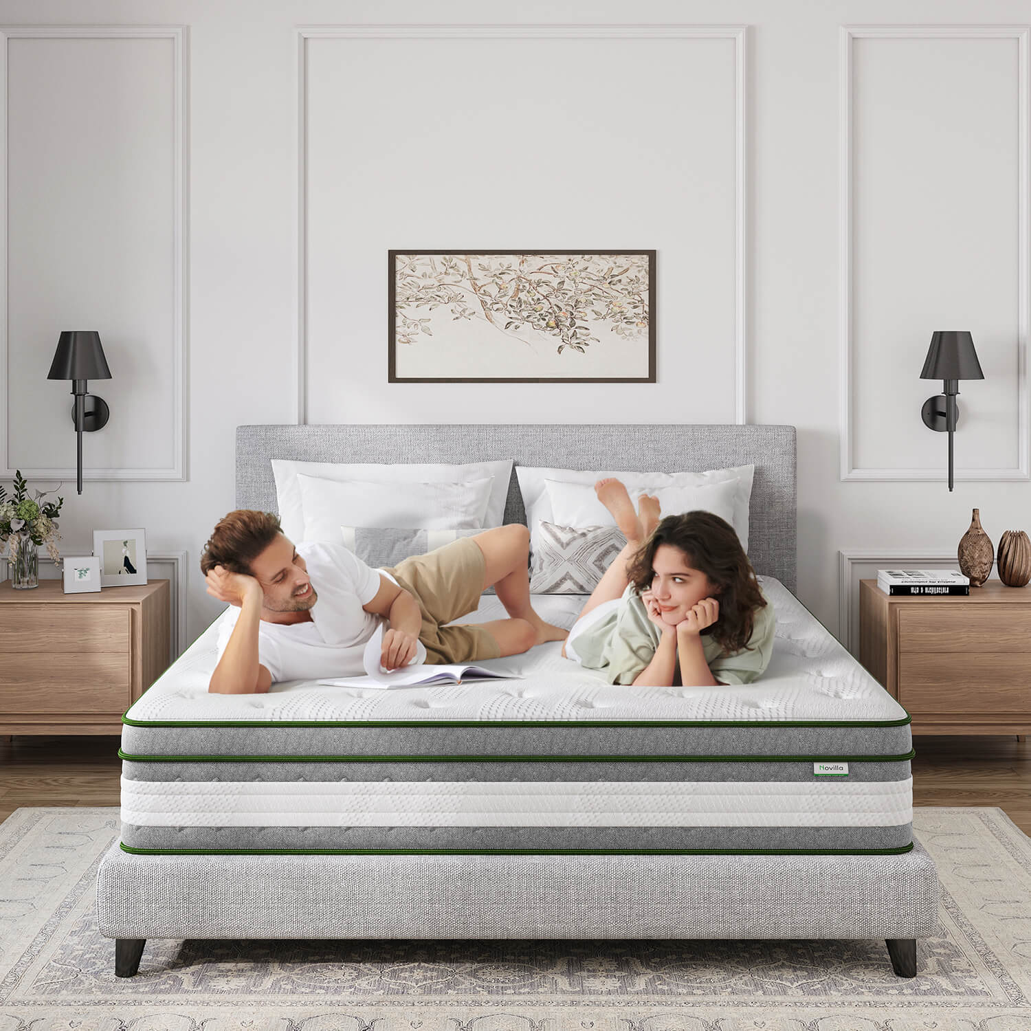 Couple relaxing on Novilla Vitality 12-inch hybrid mattress with green trim, on a grey bed frame.