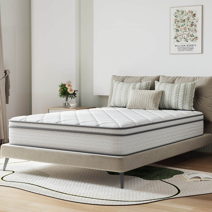 AirBreeze Hybrid Mattress with quilted top and grey trim on a bed frame with decorative pillows.