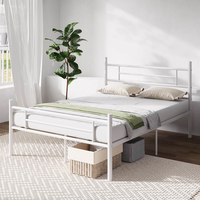 White metal bed frame with white mattress, pillows, green throw, and storage baskets underneath. Modern bedroom decor.